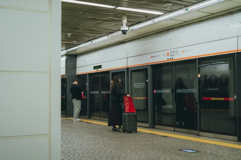 Traveler with a suitcase waiting on a Seoul subway platform