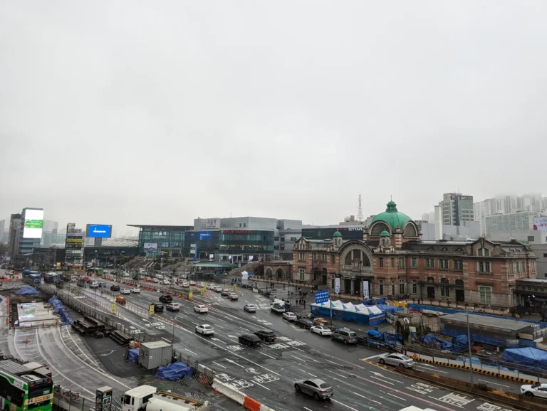 Modern Seoul Station beside the green-domed former station building across the square