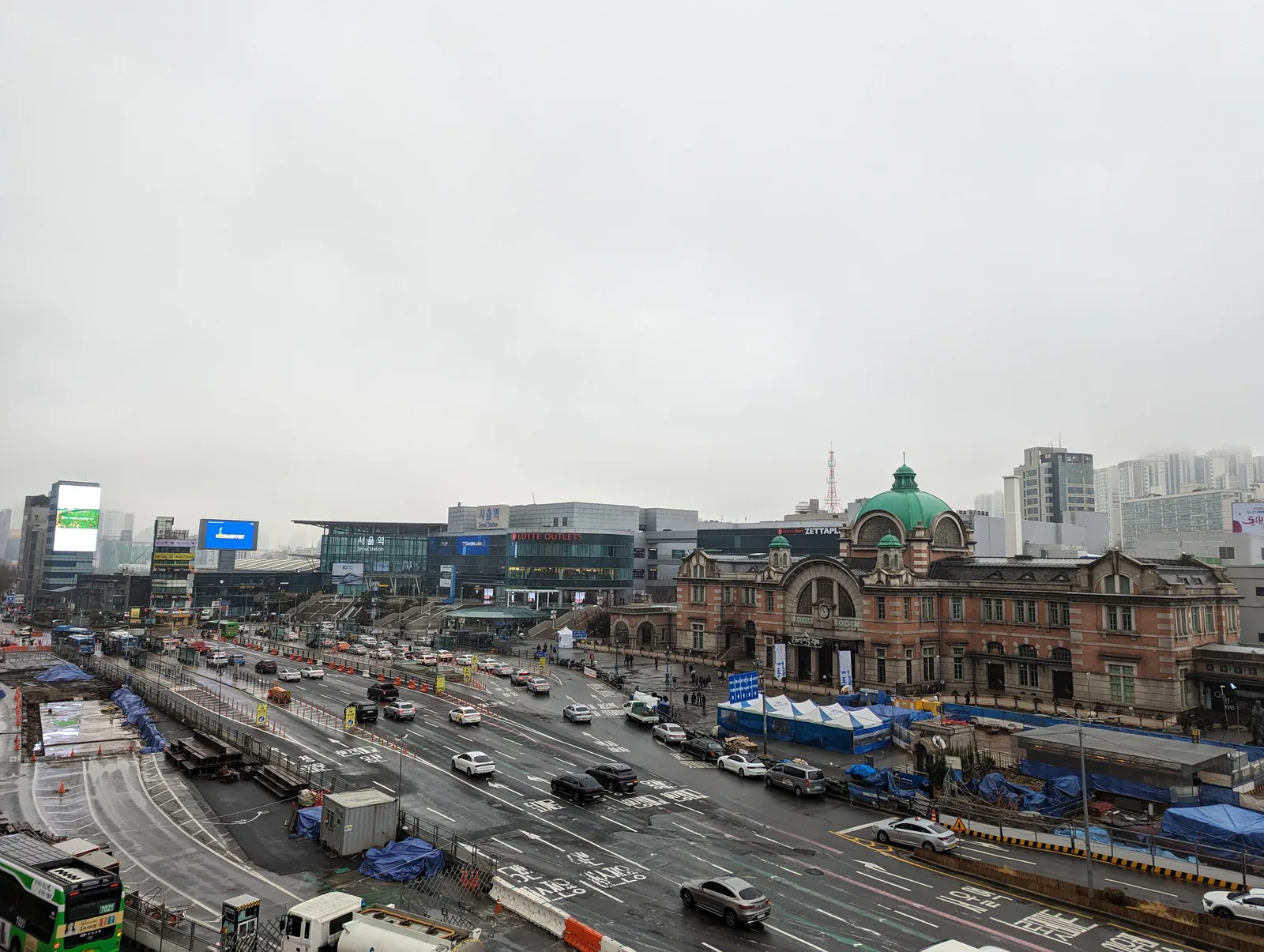 Modern Seoul Station beside the green-domed former station building across the square