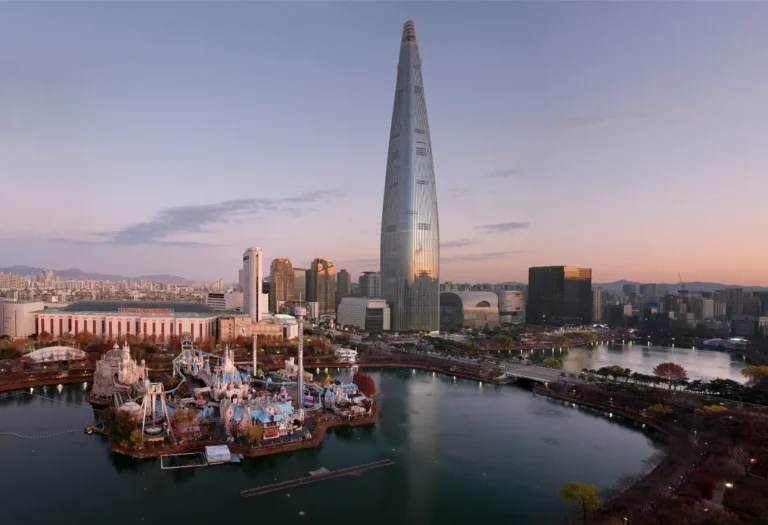 Lotte World Magic Island and Lotte World Tower beside Seokchon Lake at sunset