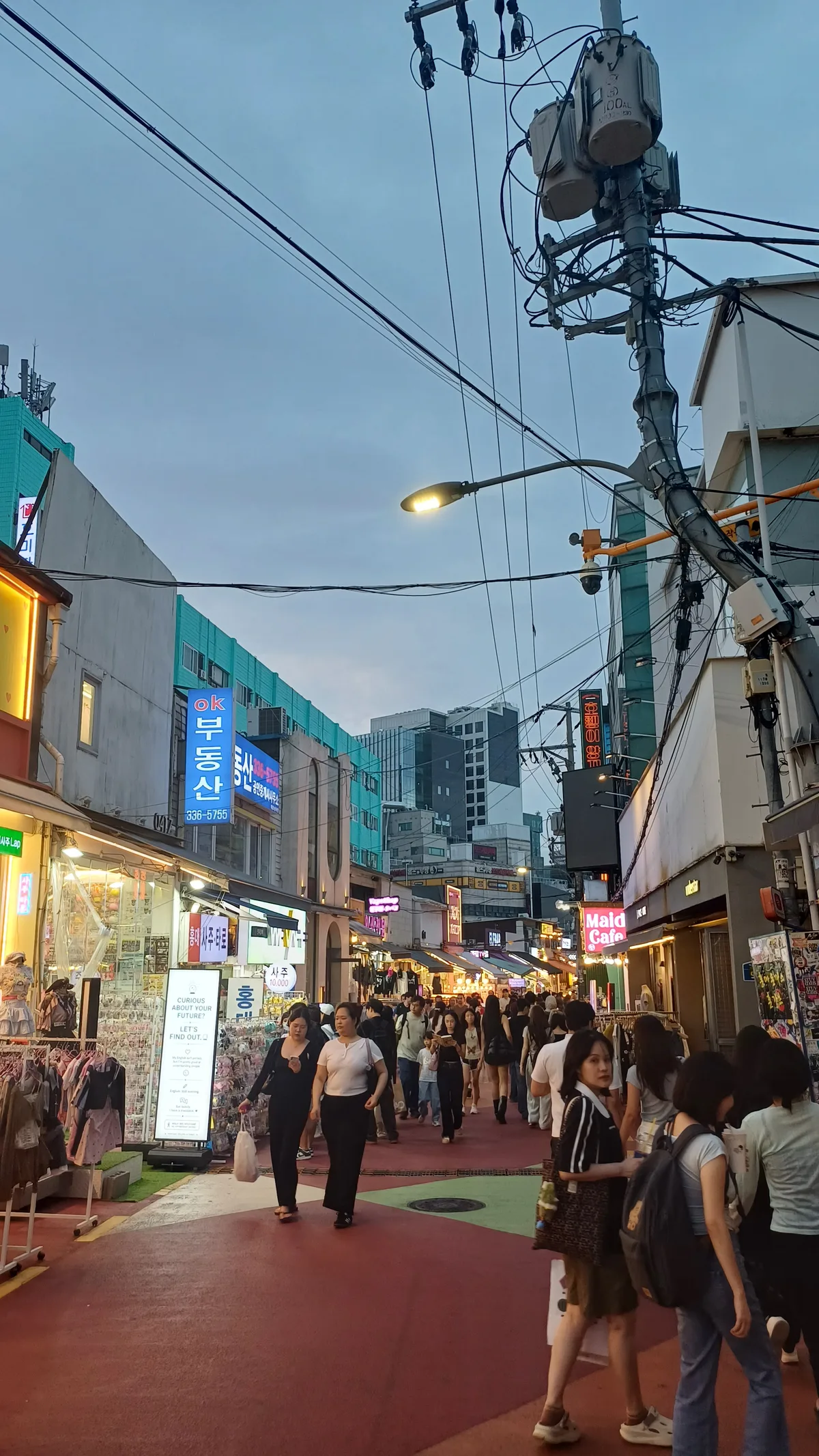 Shoppers and pedestrians walking along Hongdae Red Road in the evening