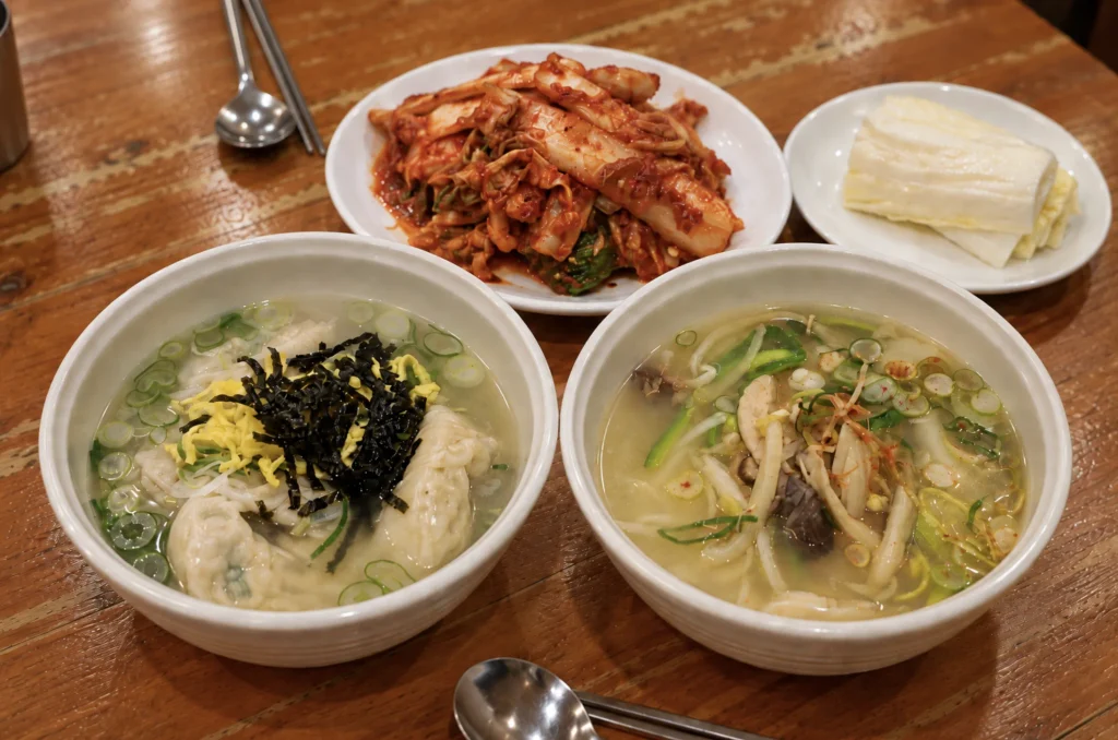 Hwangsaengga jumbo dumpling soup and beef-broth kalguksu served with kimchi