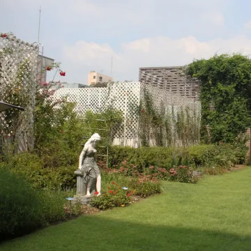 Garden terrace with flowers and a sculpture at Sejong Hotel
