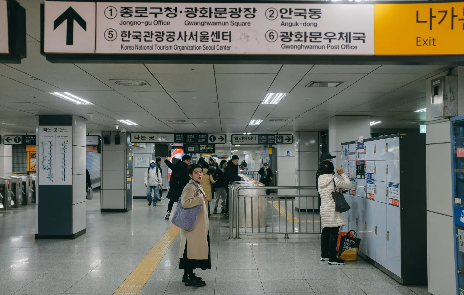 Concourse at Jongno 3-ga Station with exit signs, fare gates, lockers, and commuters