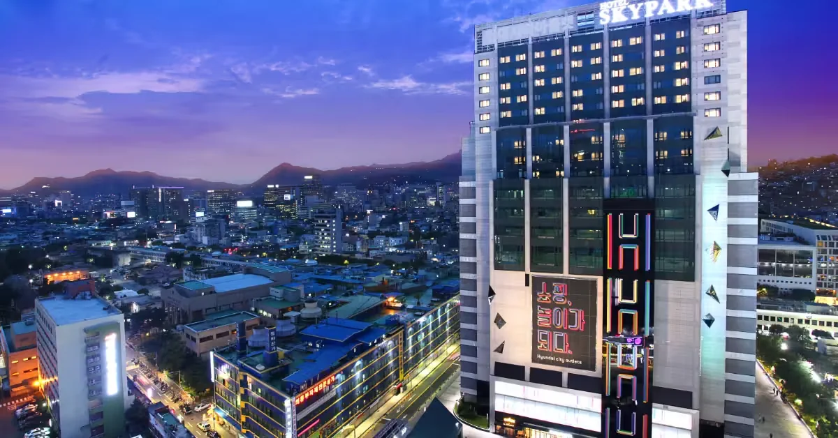 Hotel Skypark Kingstown Dongdaemun tower above Hyundai City Outlets at dusk