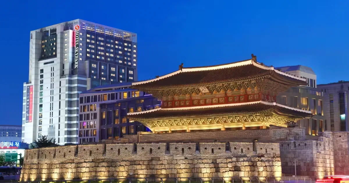 Heunginjimun Gate illuminated at night with Hotel Skypark Kingstown behind it