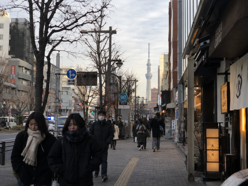 겨울 외투와 목도리를 착용하고 일본 거리를 걷는 사람들